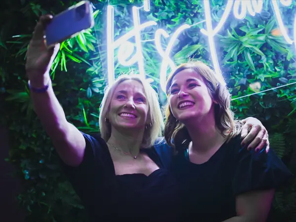 posing for selfie with neon sign