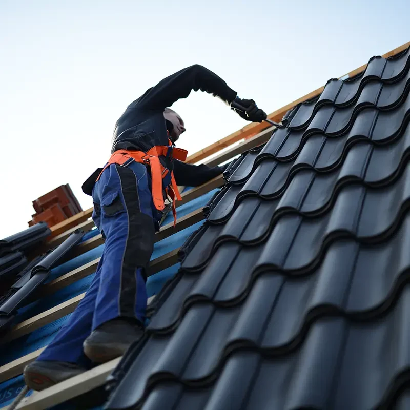 roofer working on tiling roof